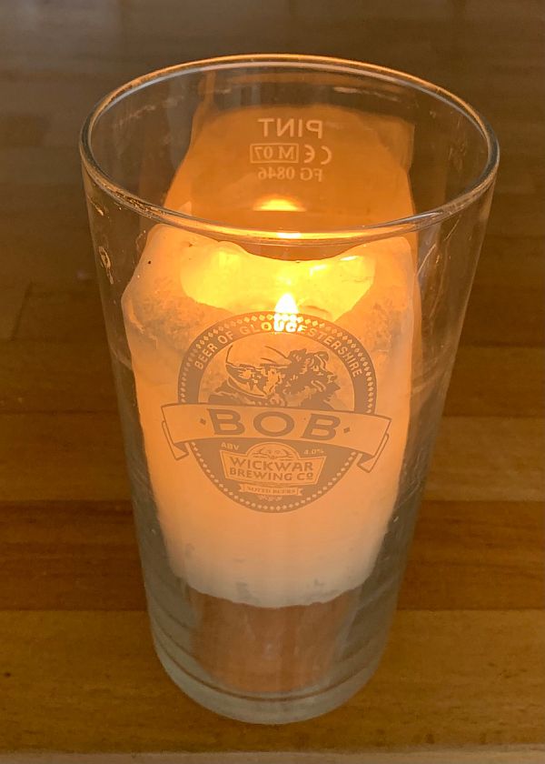 A candle lit for Diddley in a Pint Beer Glass from the Wickwar Brewing Company "Beer from Gloucester" with the name Bob on it. 