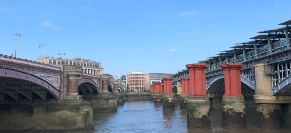 Blackfriars Bridges. Left: road. Right: railway, with station and solar roof on top. Middle: the piers of the original railway bridge.