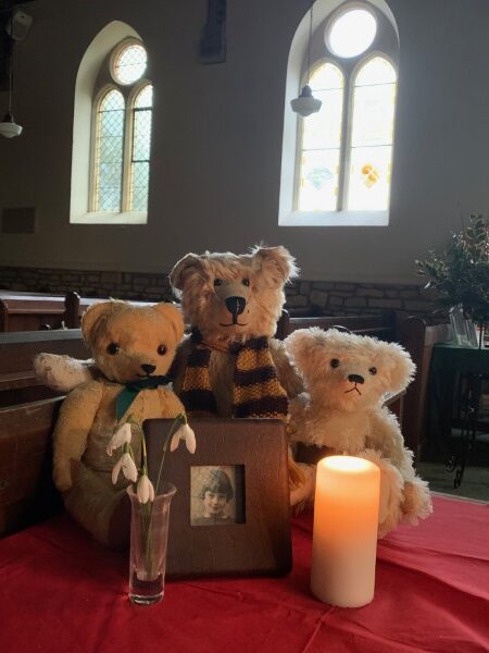 Bertie, Trevor & Eamonn with a candle lit for Diddley and a vase of Snowdrops in Slad Church.
