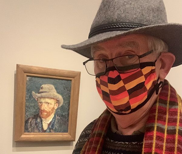 Stress Awareness. Bobby, wearing a multi-coloured facemask, with a self portrait of Van Gogh behind.