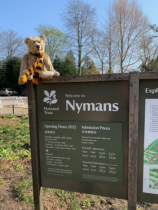 Bertie sat on the "Welcome to Nymans" sign.