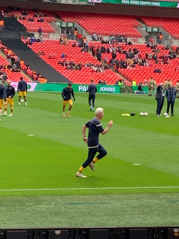 Clive, Sutton United's Kitman, running on the pitch.