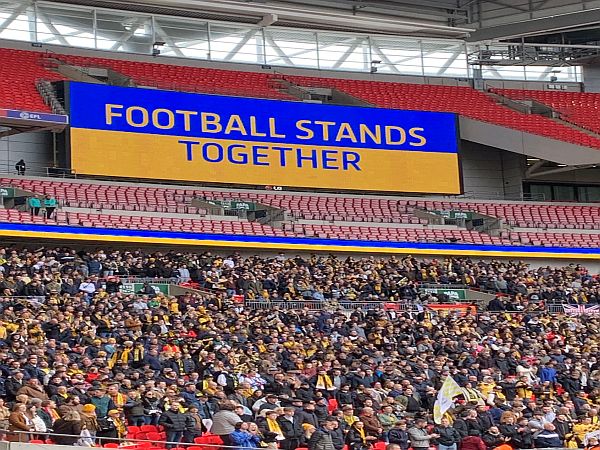 The text "Football stands together" on the Ukrainian flag.