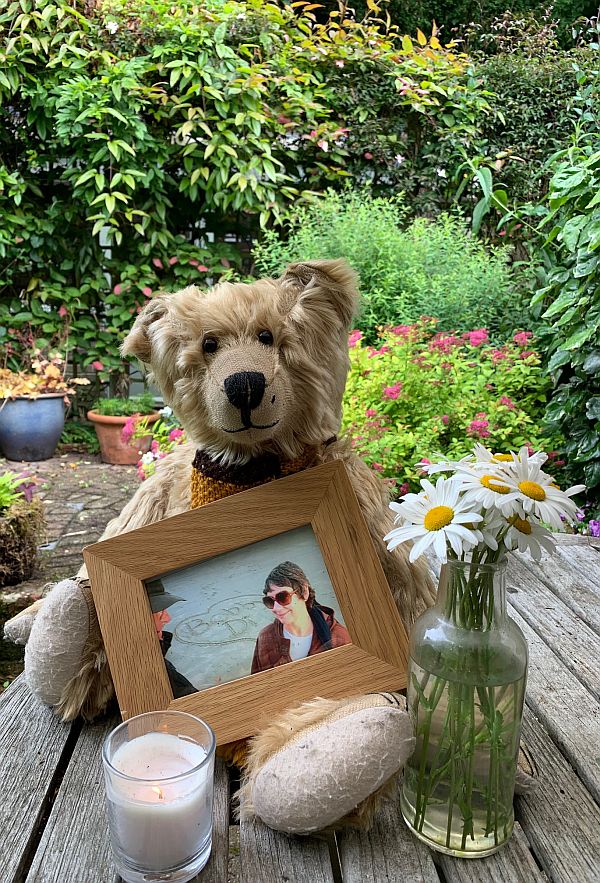 Bertie, with a framed picture of Diddley a vase of Moon Daisies and a candle lit for Diddley.