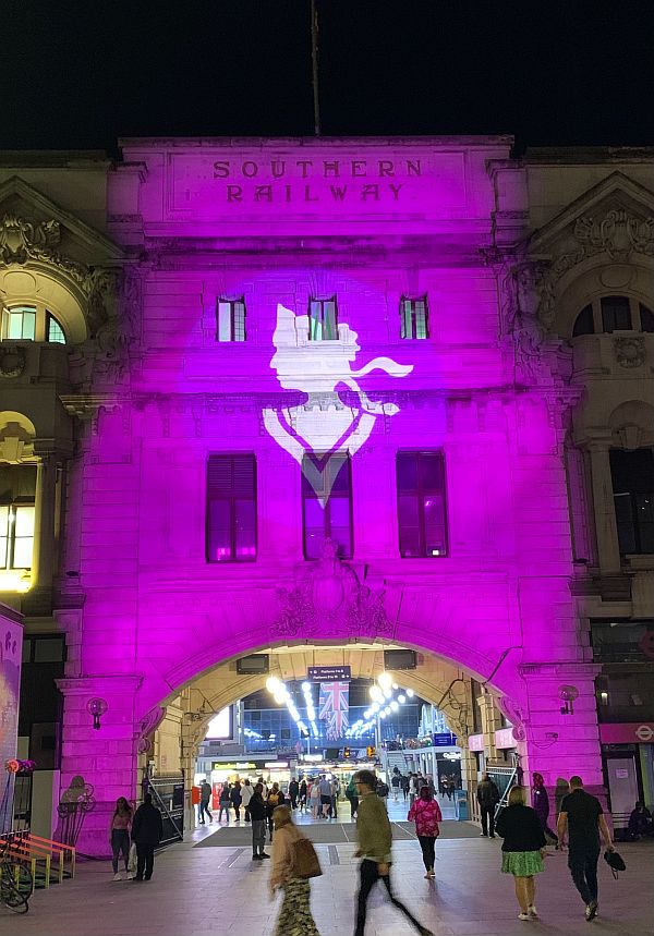 Victoria Station entrance lit up in Royal Purple.