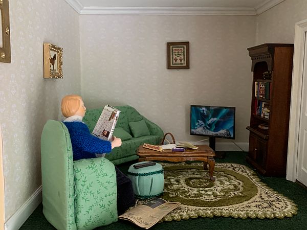 Gill: "Grandpa Olivier keeping out of the way and reading his paper. Sampler and horse picture are both cross-stitched."