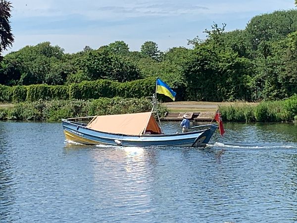 Small motor boat in Ukrainian colours with a Ukrainian flag.