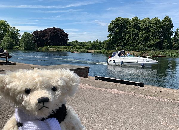 Trevor on the Thames riverside walk with a smart cruiser going by.